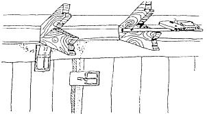 Figure 3. Overhead trap sets are particularly useful for roof rats. Trap at left is modified by fastening a piece of cardboard to expand its trigger size (traps with expanded treadles can also be purchased from several manufacturers). Traps may be nailed to beams or studs and secured to pipes with wires.